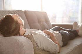 Man resting at home after dental implant surgery