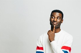 Curious man standing against gray background