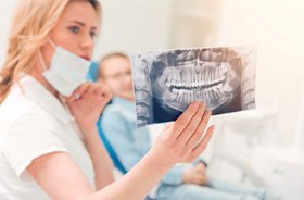Dentist examining patient’s X-ray