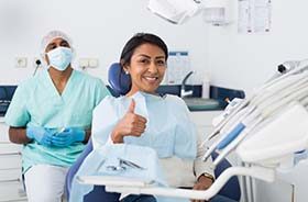 Woman gives thumbs up while visiting her Lebanon emergency dentist 