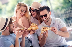 Group of friends eating pizza together