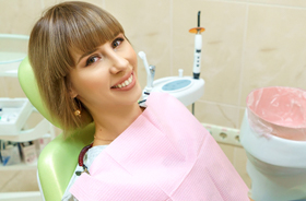 Happy female patient relaxing in dental treatment chair