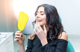 Female patient admiring the results of her cosmetic dentistry treatment