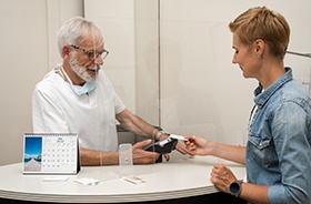 Patient using card to pay for dental services