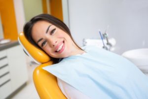 Dental patient reclining in treatment chair, smiling
