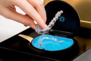 Hand taking Invisalign aligner from storage case