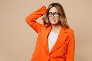 Confused woman wearing orange blazer