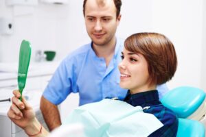 Cosmetic dentistry patient looking at her smile in mirror
