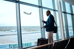 Man standing next to window in airport